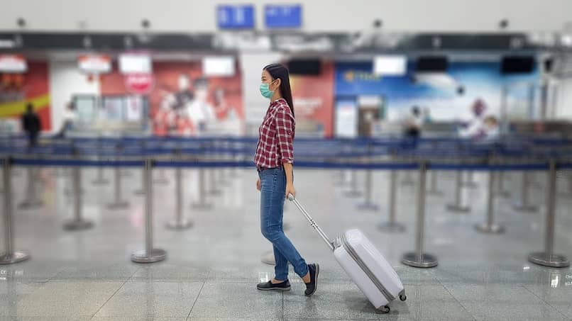 kobieta przeciągając walizkę lotnisko 