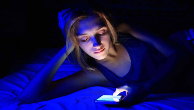 Kobieta ogląda swój telefon w nocy