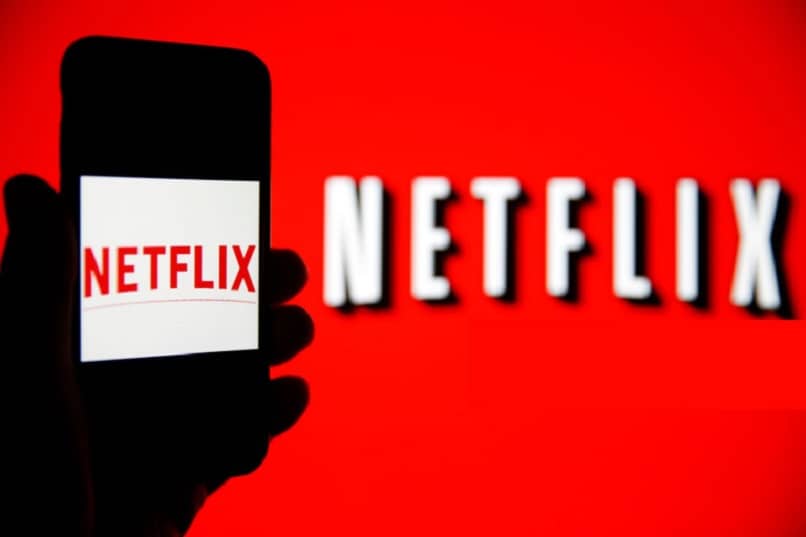 logo Netflix w tle i na smartfonie