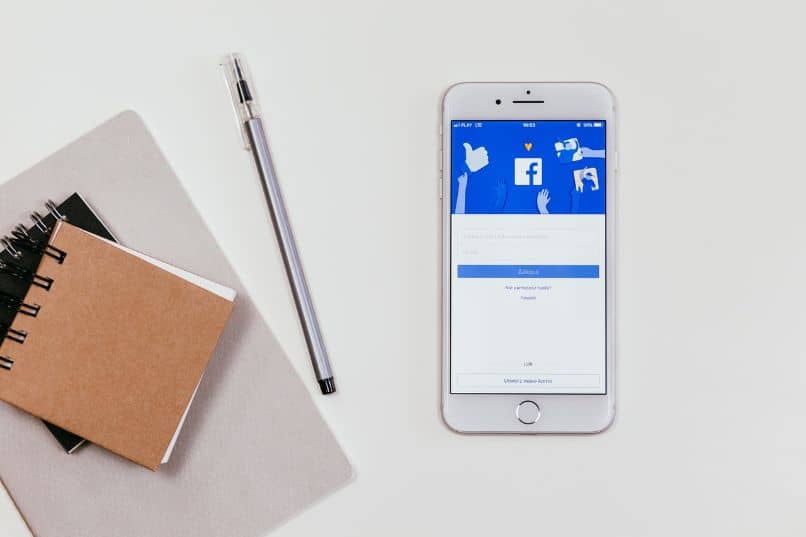 smartfon z aplikacją Facebook i notatnikami