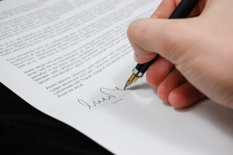 ręka podpisująca dokument biznesowy