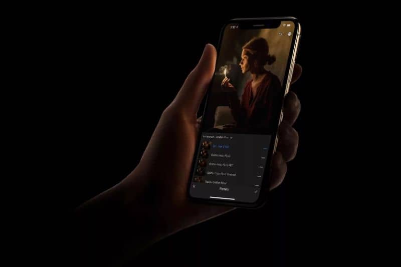 telefon w jednej ręce z ciemnym zdjęciem Preset Lightroom Mobile