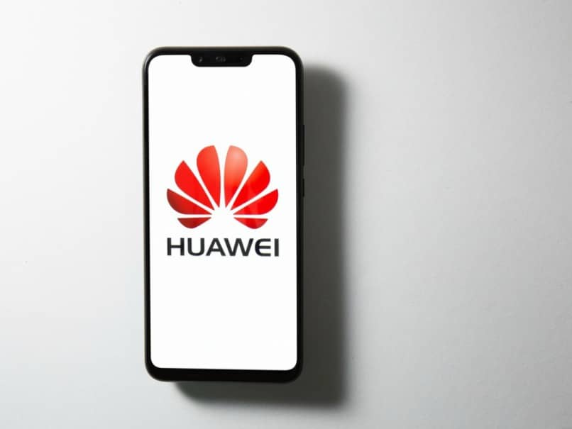 Telefon komórkowy Huawei z logo na szarym stole