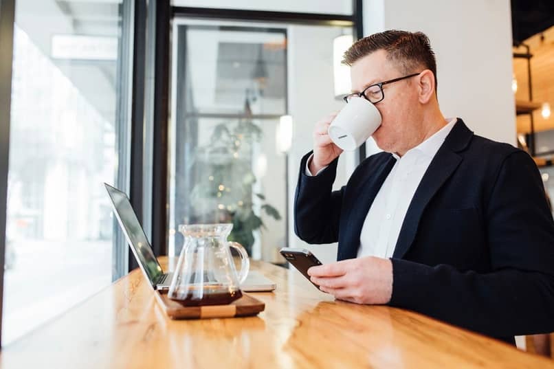 człowiek pracuje laptop spokojnie pić kawę 