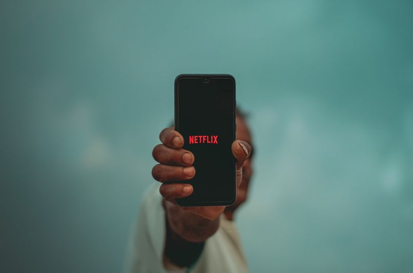 człowiek ze smartfonem z Netflixem