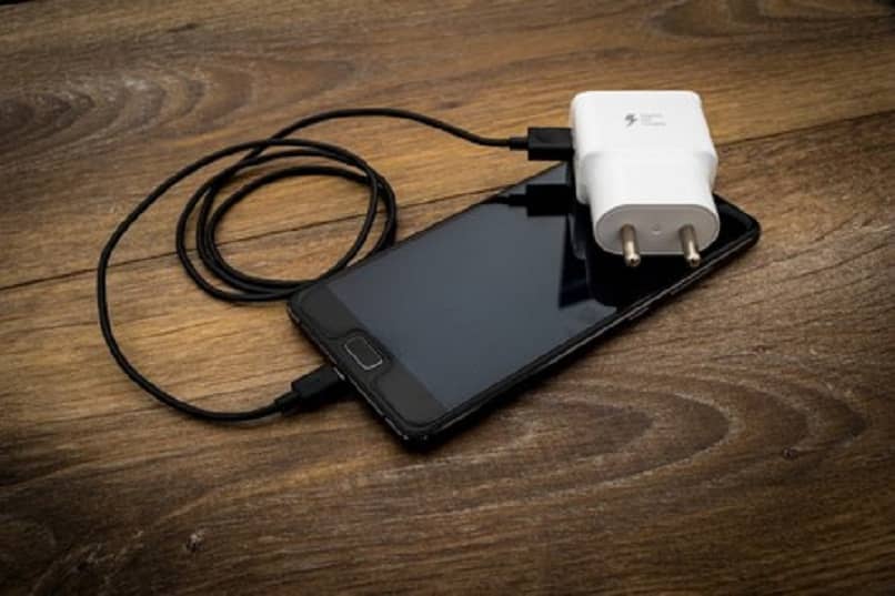 urządzenie mobilne z kablem USB i białym adapterem 
