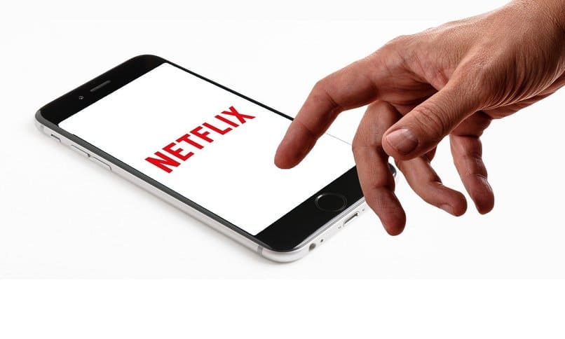 osoba korzystająca z telefonu komórkowego z logo Netflix na ekranie