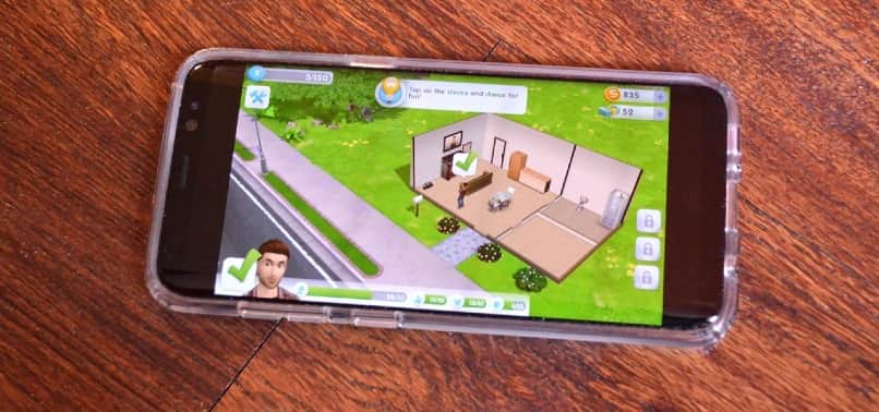 graj w sims mobile na czarnym smartfonie