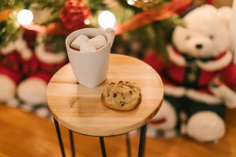 mleko i ciasteczka ze świątecznymi dekoracjami w tle