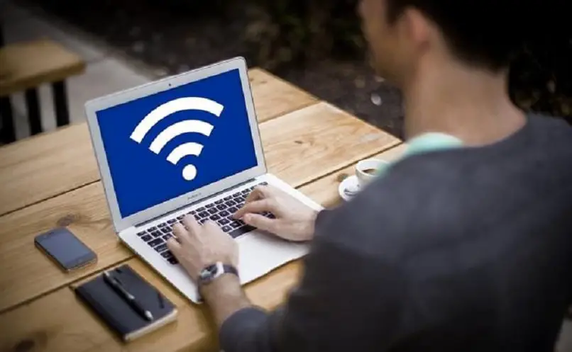 osoba oceniająca logo Wi-Fi na swoim komputerze