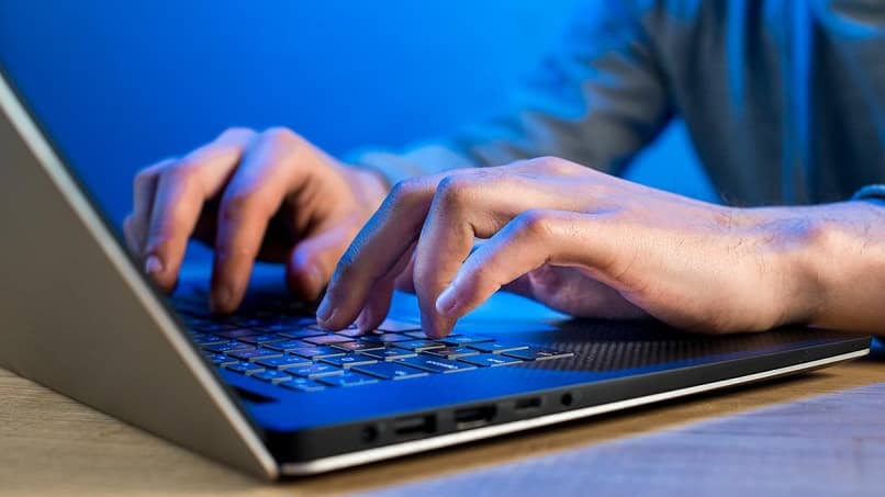 mężczyzna piszący na laptopie