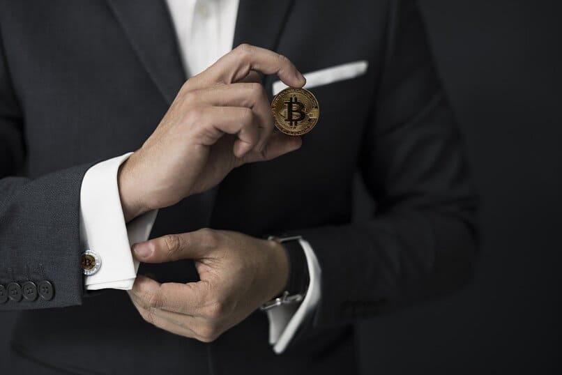 mężczyzna trzymający monetę bitcoin