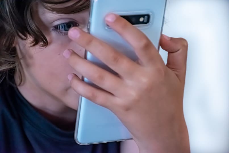 chłopiec patrząc na swój telefon komórkowy
